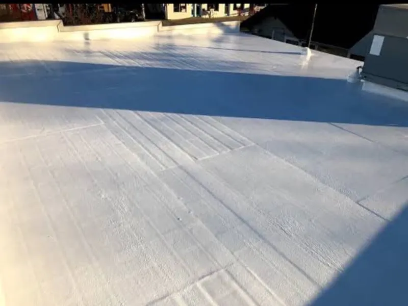 Detailed view of white silicone roof coating layer drying to form a seamless rubber membrane